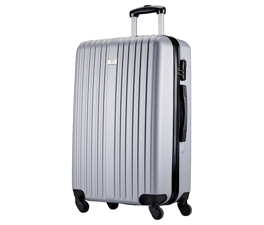 Ein silberner Koffer mit vertikalen Rillen, schwarzem Griff und Rollen steht auf einem weißen Hintergrund.