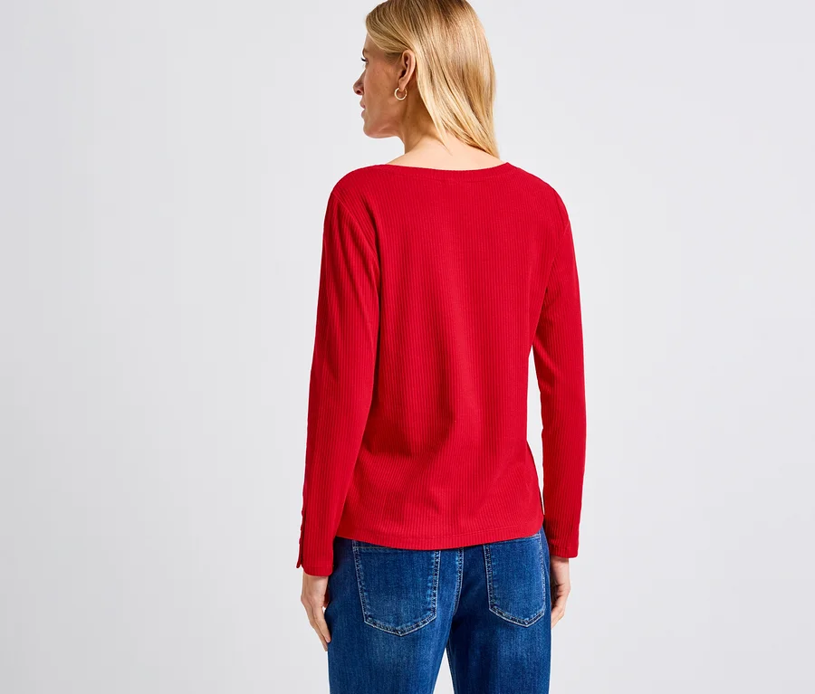 Eine blonde Frau von hinten trägt ein rotes Street One Rippshirt und Jeans.