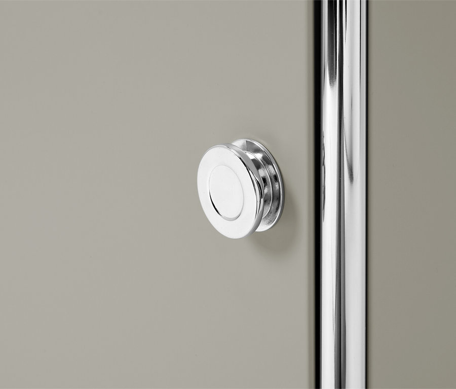 Nahaufnahme einer grauen Schranktür mit einem runden, silbernen Griff und einer silbernen Stange.