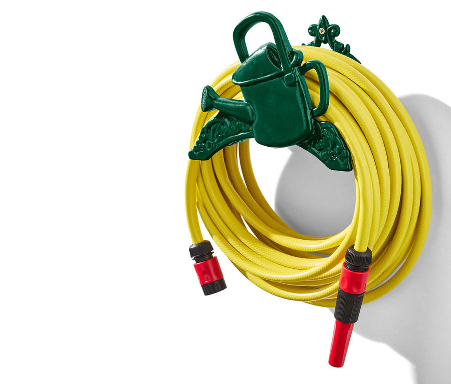 Gelber Gartenschlauch auf einer dunkelgrünen Halterung in Form einer Gießkanne aufgerollt.