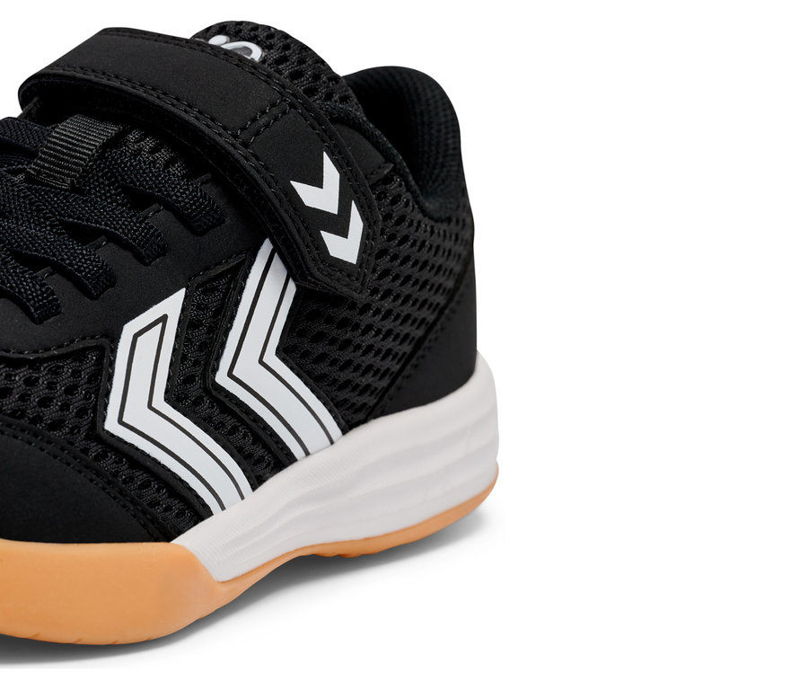 Detailansicht eines schwarzen Sneakers mit weißen Streifen und Klettverschluss.