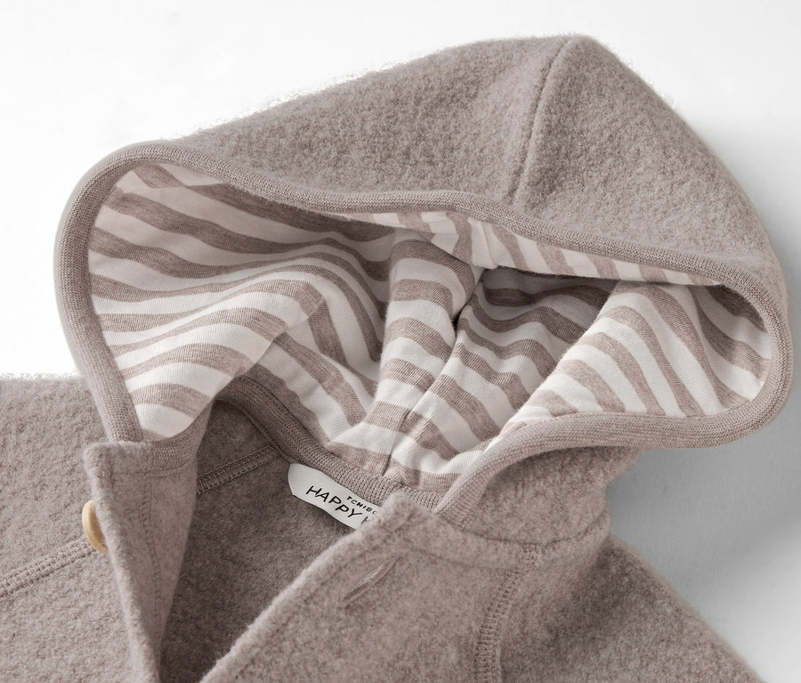 Nahaufnahme einer Kapuze aus beigem Wollfleece mit einem Futter aus beigen und weißen Streifen.