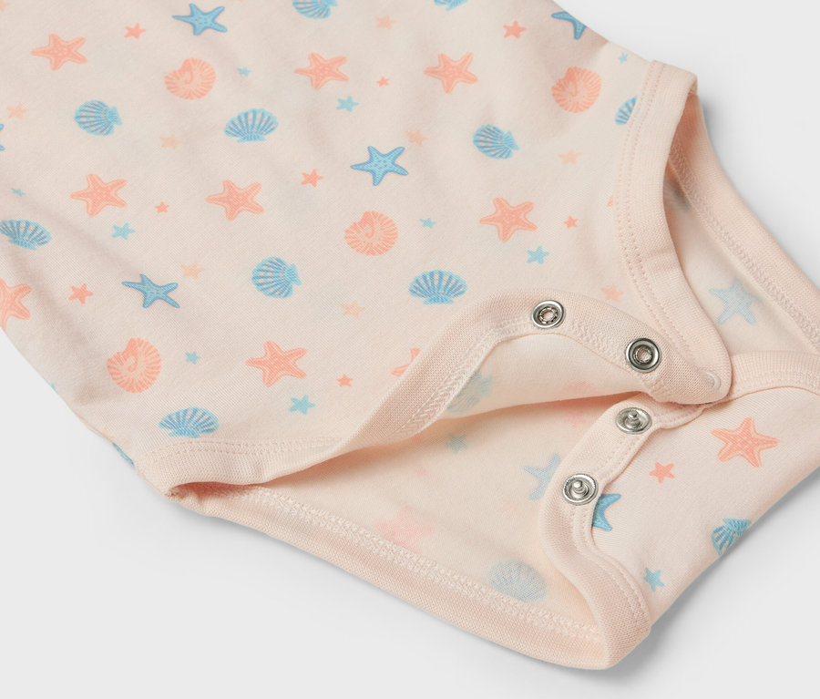 Detailansicht eines hellrosa Babybodys mit Seestern- und Muschelmuster.