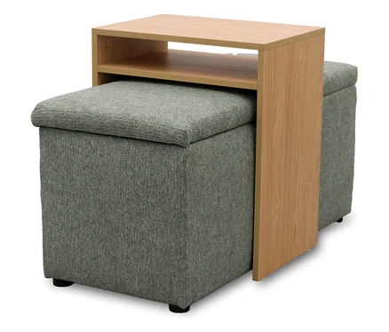 Zwei graue gepolsterte Aufbewahrungshocker mit einem hellen C-förmigen Beistelltisch aus Holz, der über einem Hocker platziert ist und zwei Ablagen hat.