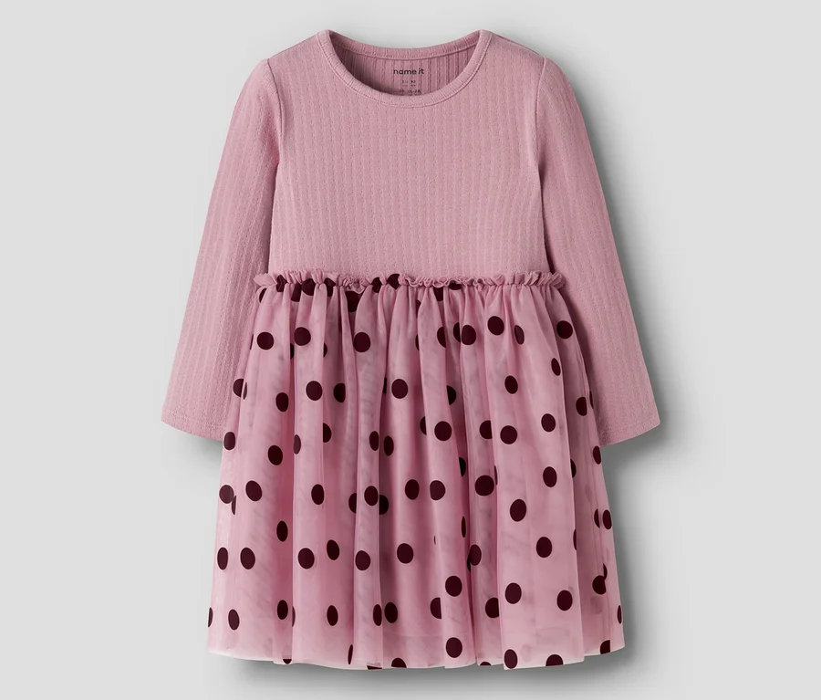 Rosa Langarmkleid mit geripptem Oberteil und einem durchsichtigen Rock mit dunklen Tupfen. Die Taille ist gerafft.