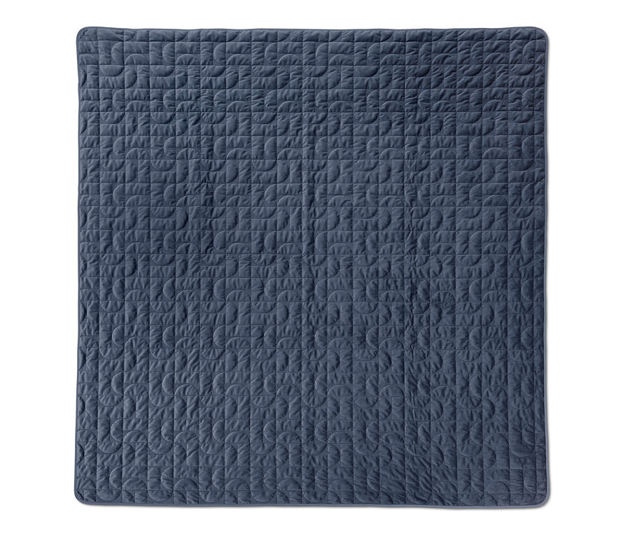 Blauer Bettüberwurf mit geometrischem Muster.