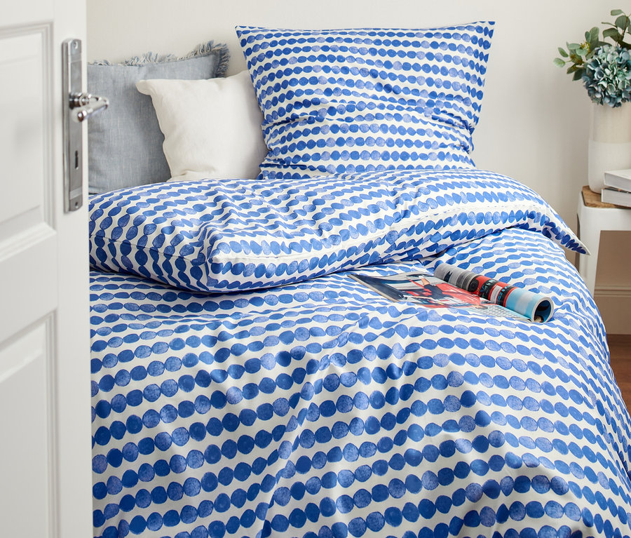 Schlafzimmer mit einem Bett mit Premium-Baumwoll-Bettwäsche mit blauem Muster, Doppelgröße und Normalgröße.