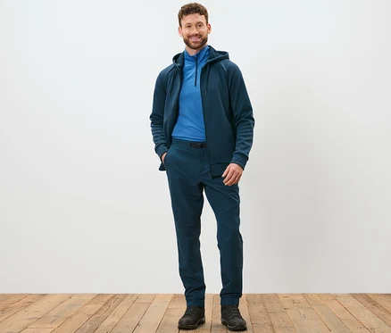 Mann steht und posiert in Thermohose mit Gürtel.