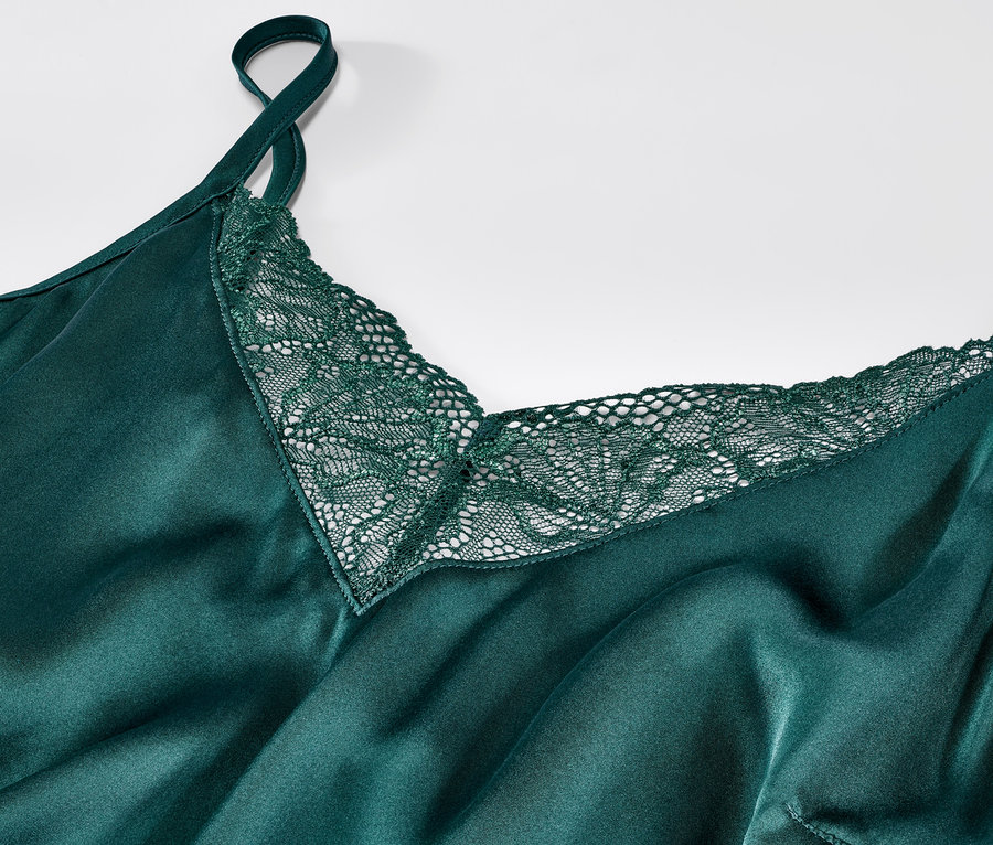 Detailansicht eines grünen Neglige aus reiner Seide mit Spitze.
