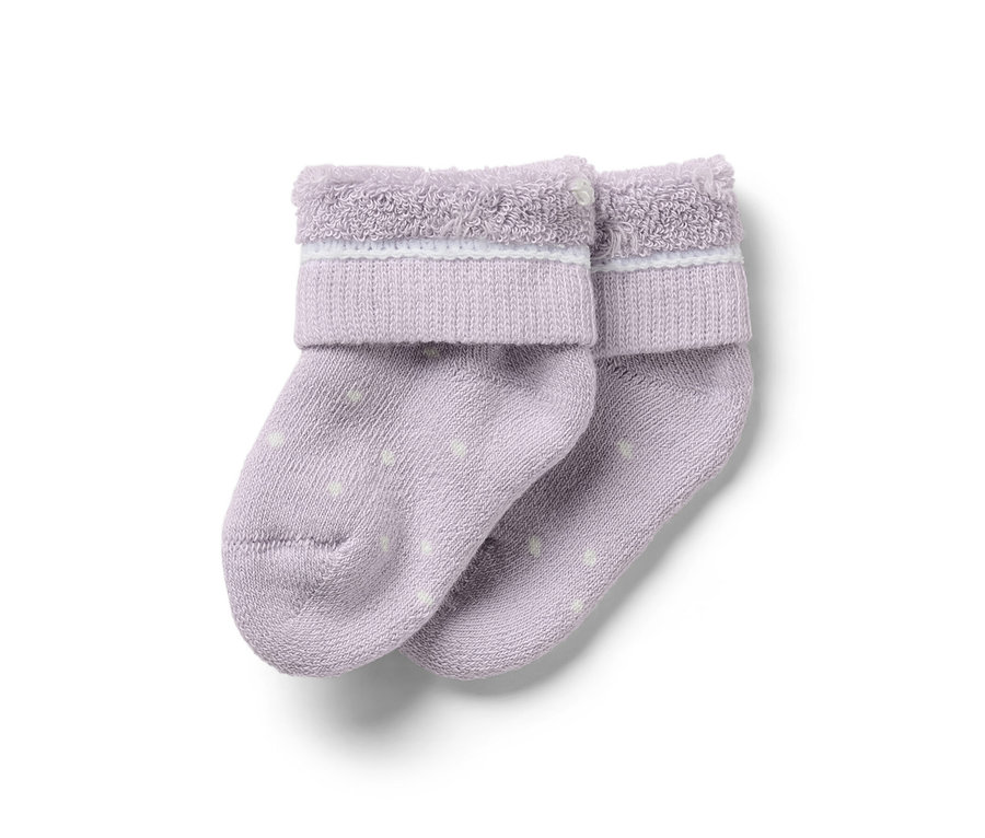 Zwei lila Baby-Socken mit weißen Punkten.