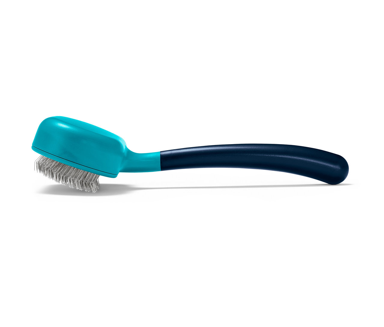 Eine Tier-Fellbürste mit blauem Griff liegt auf dem Tisch.