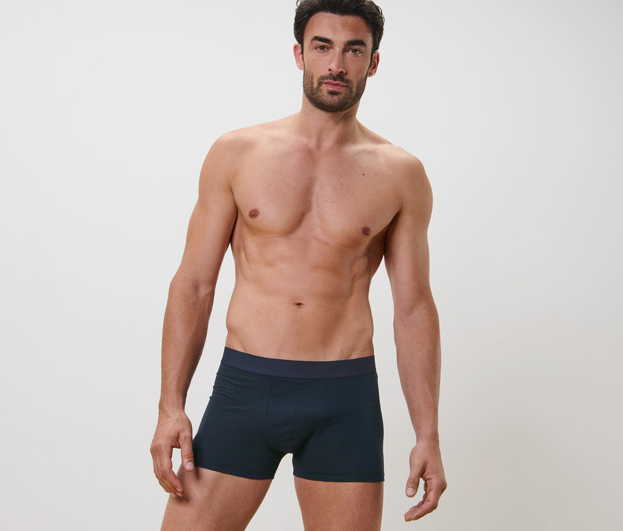 Mann posiert im Bild und trägt 2 Slipboxer.