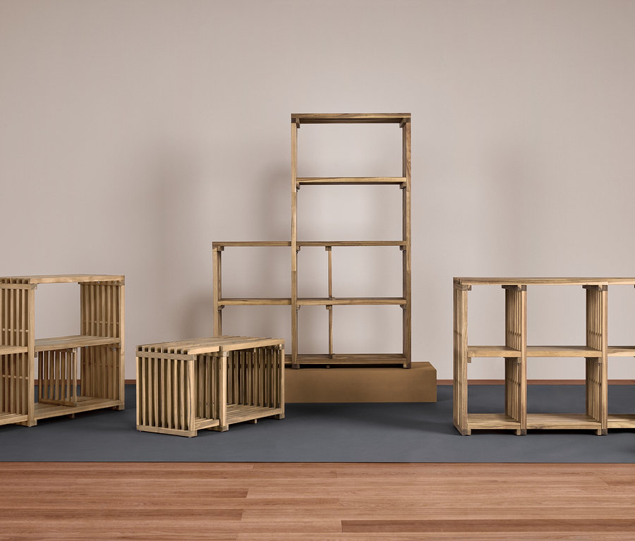 Vier hölzerne Regale unterschiedlicher Größe auf einer grauen Unterlage auf einem Holzboden.