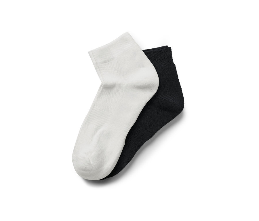 Zwei Paar Sportsocken COOLMAX®, ein Paar weiß, ein Paar schwarz, liegen übereinander.