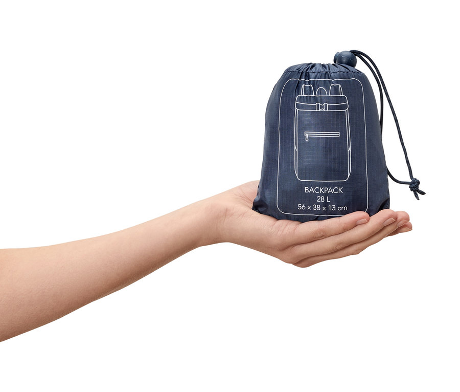 Hand hält einen dunkelblauen, verpackten 28L Rucksack mit einer weißen Rucksackzeichnung darauf.