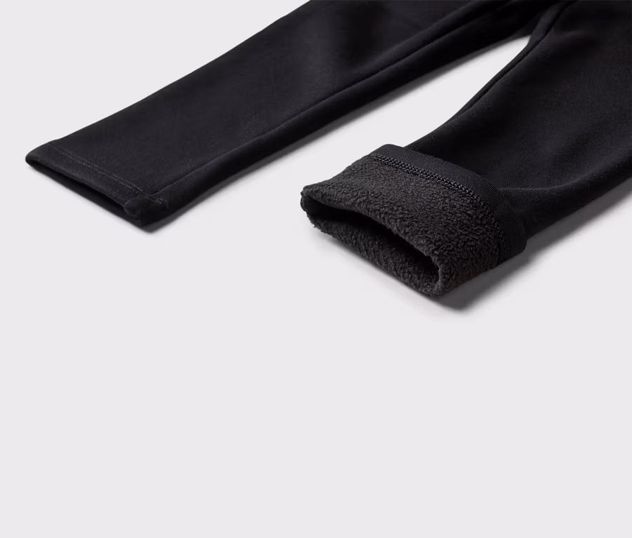 Nahaufnahme von schwarzen Leggings mit Fleece-Futter am umgeschlagenen Beinabschluss.