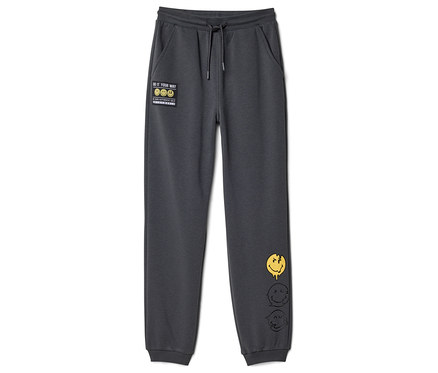Dunkelgraue SMILEYWORLD® Kinder-Jogginghose mit Kordelzug, einem "DO IT YOUR WAY"-Patch und drei schmelzenden Smiley-Gesichtern am rechten Bein.