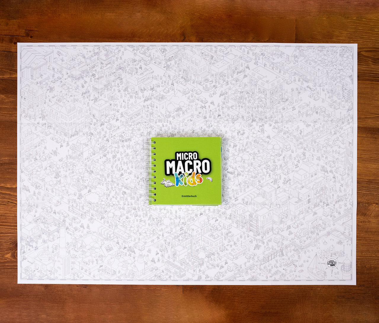 Das Spiel MicroMacro Kids »Der verrückte Stadtpark« liegt auf einem Tisch.