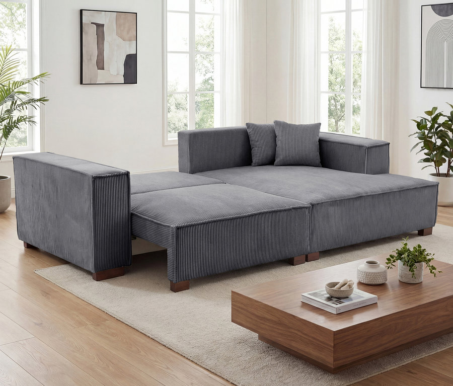 Anthrazitfarbenes Sofa »Cumello« mit Auszugsbett links und Longchair rechts im Wohnzimmer.