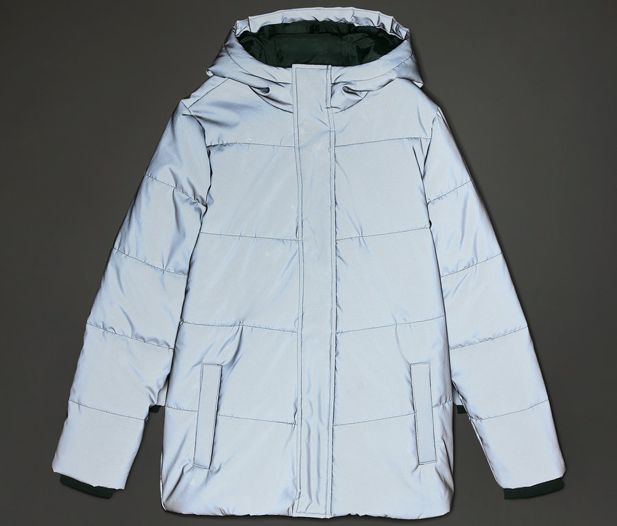 Eine graue, reflektierende Daunenjacke mit Kapuze und Taschen ist vor einem grauen Hintergrund zu sehen.