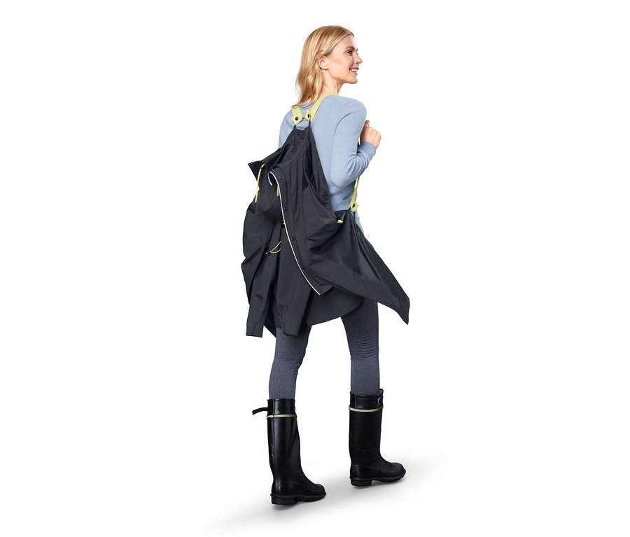 Frau geht mit einem Funktions-Regenparka über ihrer Schulter.
