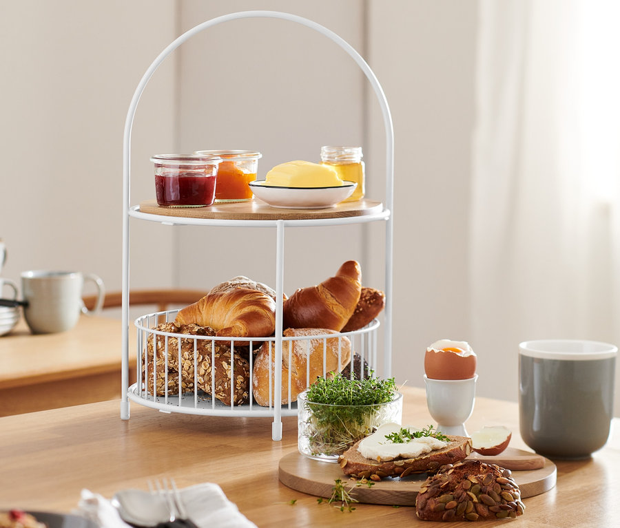Etagere mit Brotkorb auf einem Tisch mit Speisen.