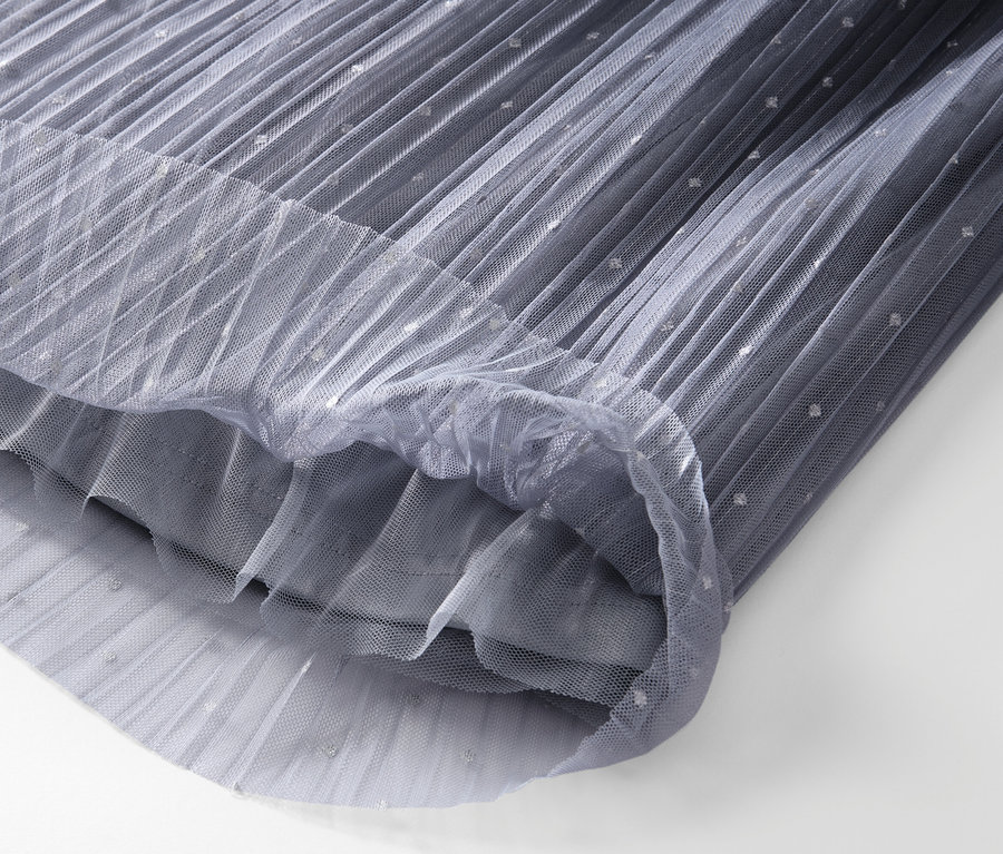 Detailansicht eines plissierten Tüllrocks mit Farbverlauf.