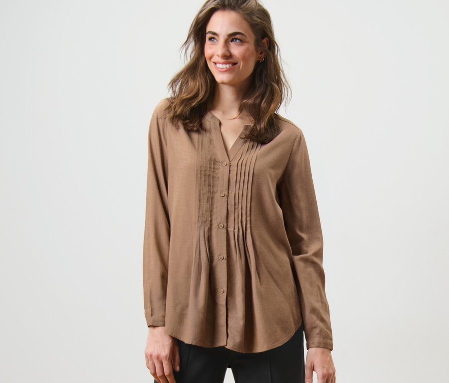 Frau posiert in Tunikabluse.