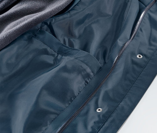 Detailansicht einer 3-in-1-Regenjacke, Innenseite mit Tasche und grauer Fleece-Schicht.