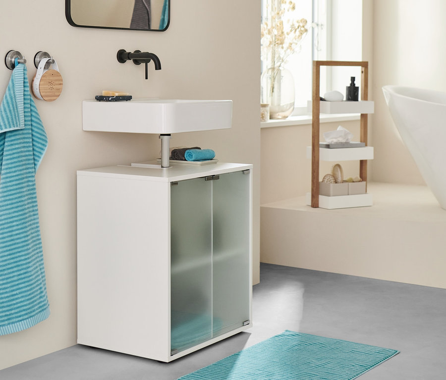 Badezimmer mit Waschbeckenunterschrank, Sound-Box, aqua Duschvorleger und Handtüchern.