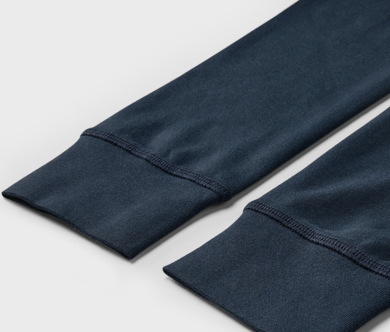 Detailaufnahme von marineblauen Sweatshirt-Ärmeln mit Bündchen.