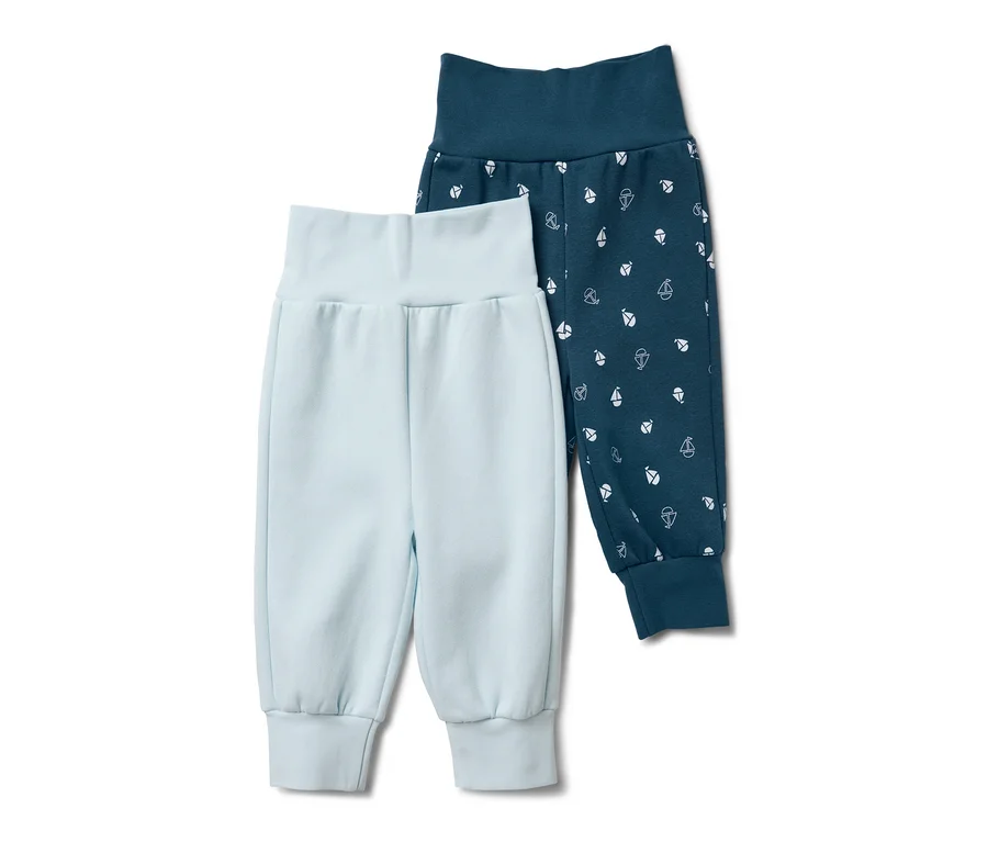 Zwei Baby-Sweathosen, eine hellblau, die andere dunkelblau mit kleinen, weißen Segelbooten.