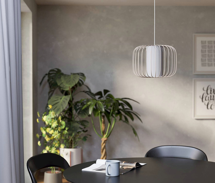 Interieur mit rundem Tisch, schwarzen Stühlen und einer modernen Lampe darüber.