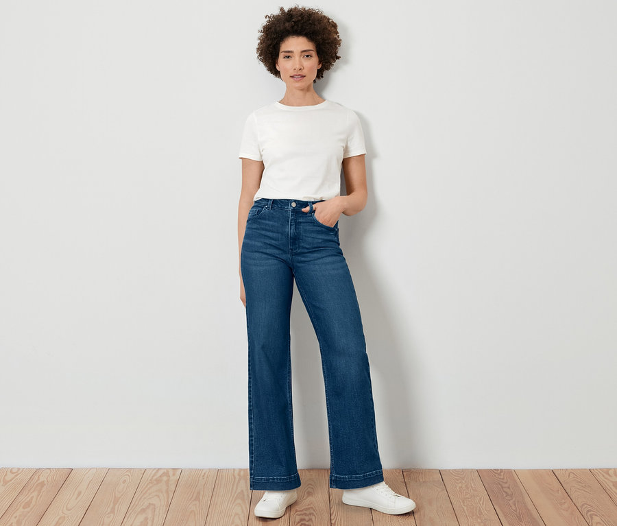 Eine Frau posiert in Wide Leg Jeans – Fit »Viki« und einem weißen T-Shirt.