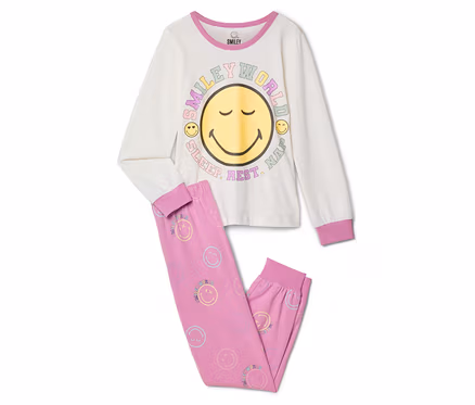 Kinder-Pyjama SMILEYWORLD®: Ein cremefarbenes Langarmshirt mit großem gelbem Smiley-Gesicht und „SMILEY WORLD SLEEP. REST. NAP.“-Schriftzug, dazu eine pinke Hose mit kleinen pastellfarbenen Smileys.