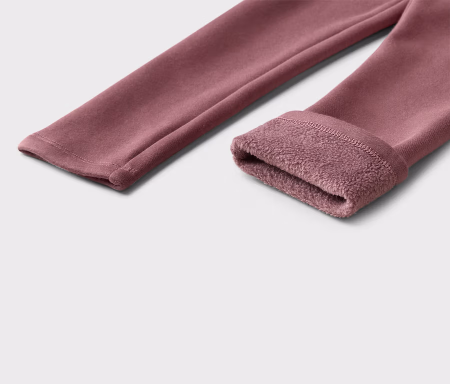 Nahaufnahme einer weinroten Leggings mit Fleece-Futter am Beinabschluss.