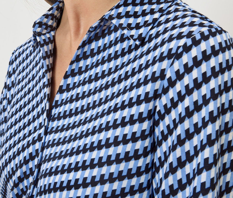 Nahaufnahme eines Hemdes mit blauem, schwarzem und weißem geometrischem Muster.
