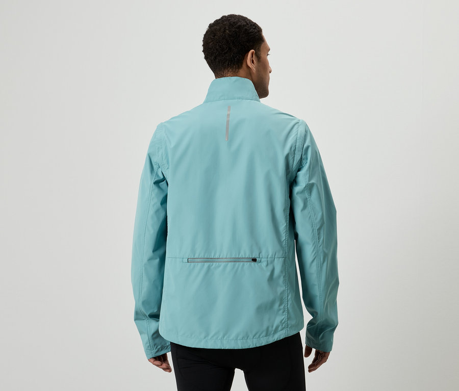 Rückansicht eines Mannes mit hellblauer Jacke und schwarzen Hosen vor einem weißen Hintergrund.