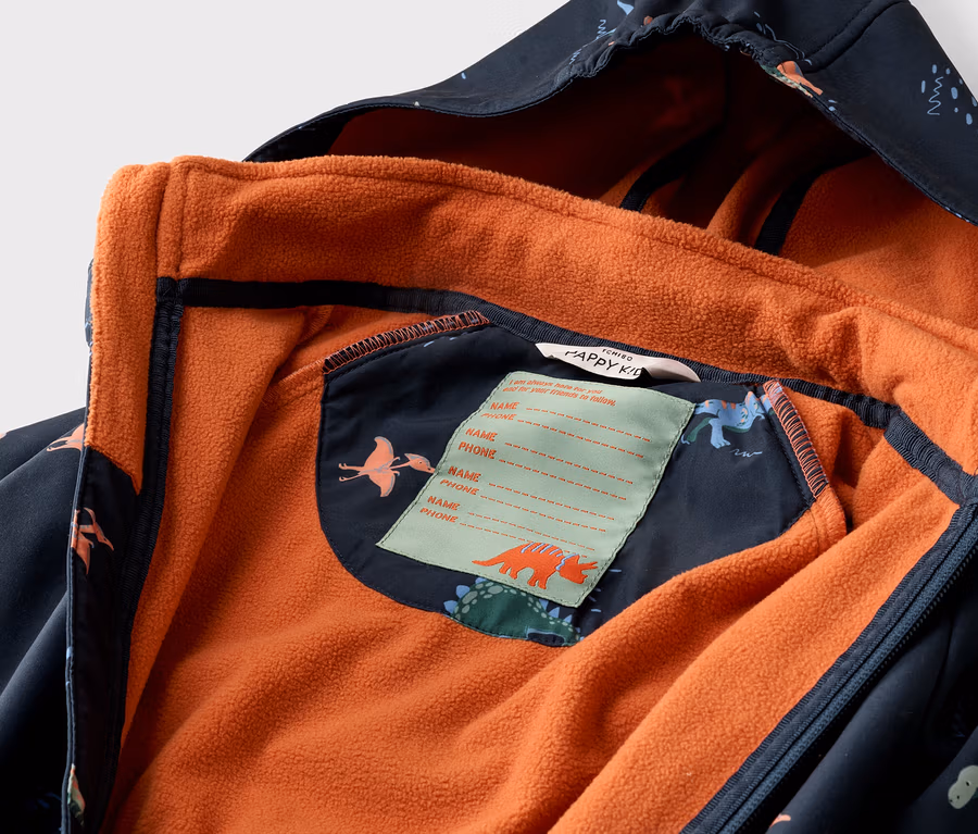 Nahaufnahme einer geöffneten, marineblauen Kinderjacke mit Dinosaurier-Muster und orangefarbenem Fleecefutter.
