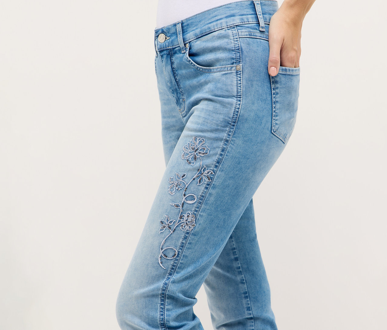 Person trägt Angels Denim »Cira Boho« Jeans mit floraler Stickerei und Hand in der Tasche.