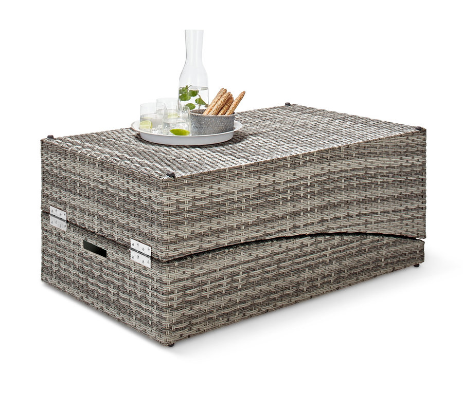 Klappbare Gartenliege aus Polyrattan mit Glaskaraffe und Gläsern auf dem Tisch.