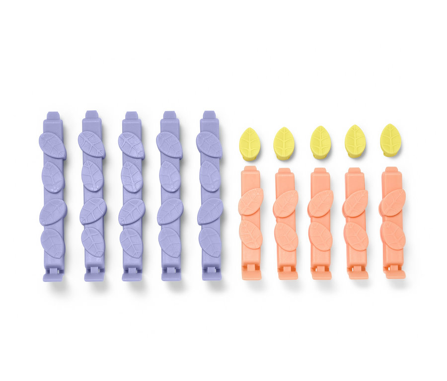 Fünfzehn Aromaclips in Lila und Pfirsichfarbe und gelbe Blätter.