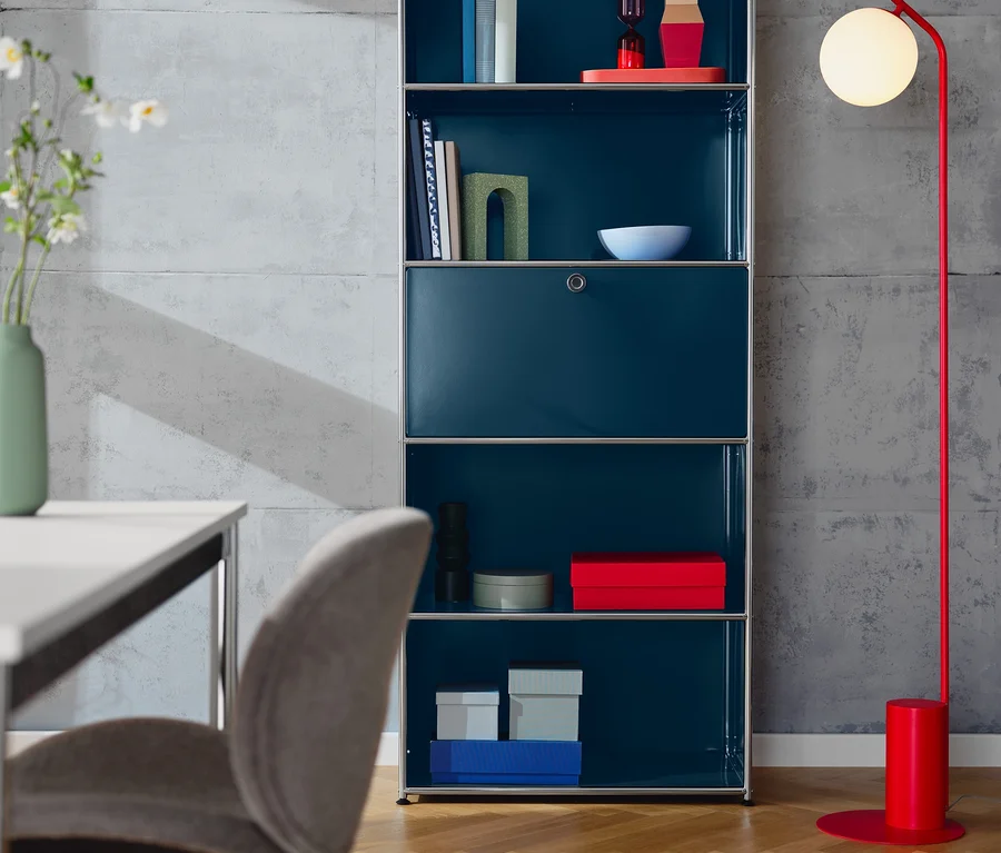 Blaues hohes Regal »CN3« mit Klappenfach und ein gepolsterter Designstuhl in Greige.