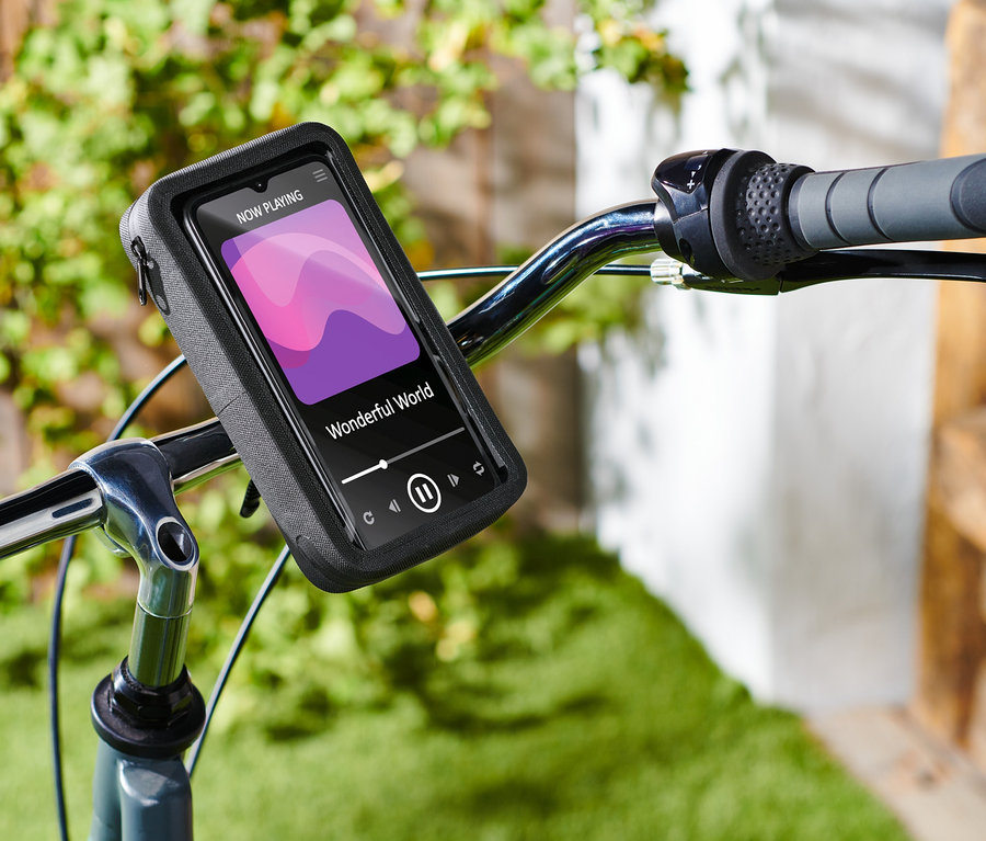 Nahaufnahme eines Fahrradlenkers mit einer montierten 2-in-1-Smartphonetasche, auf der ein Bildschirm mit laufender Musik zu sehen ist.