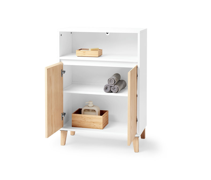 Weißes Sideboard mit zwei Türen und offenem Fach, darin Handtücher und ein Seifenspender.