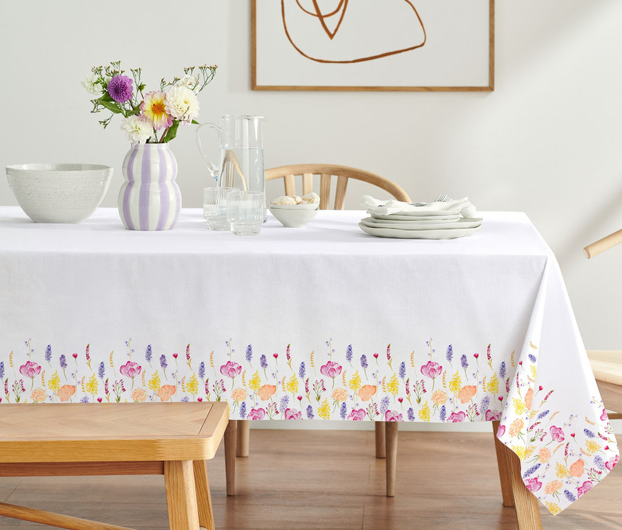 Gedeckter Tisch mit Baumwoll-Tischdecke mit Blumenmuster.