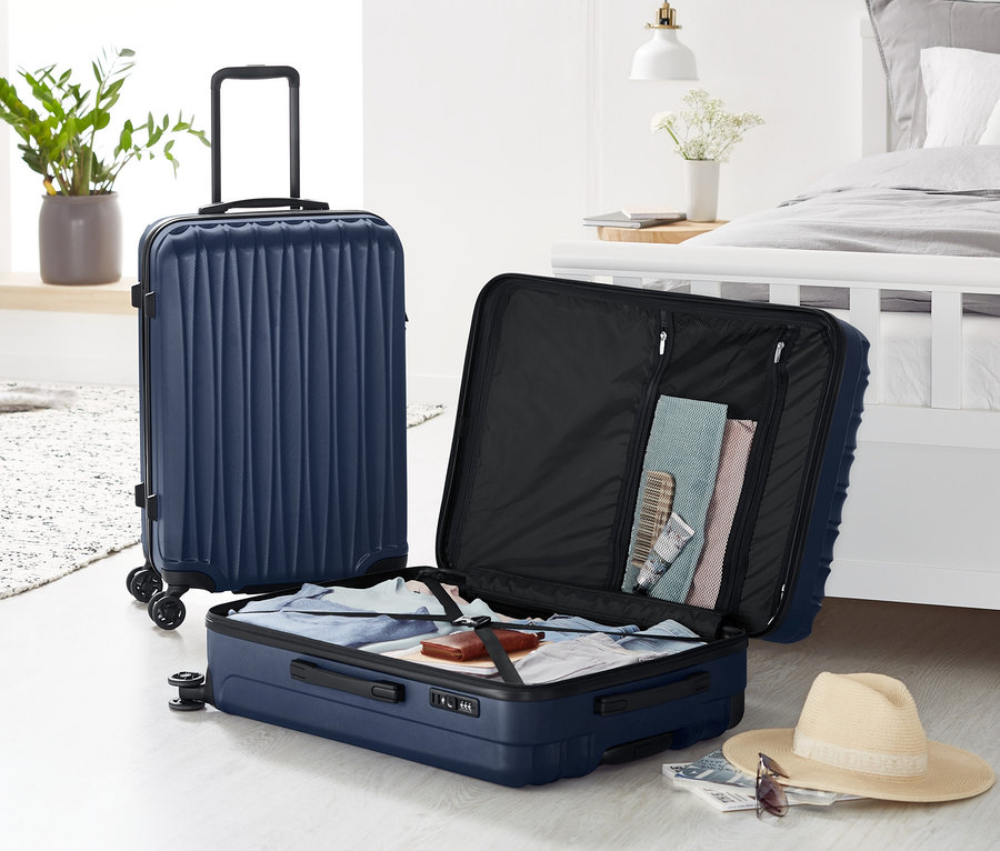 Zwei Hartschalen Koffer-Sets: ein großer steht, ein kleiner ist geöffnet und mit Kleidung gefüllt.
