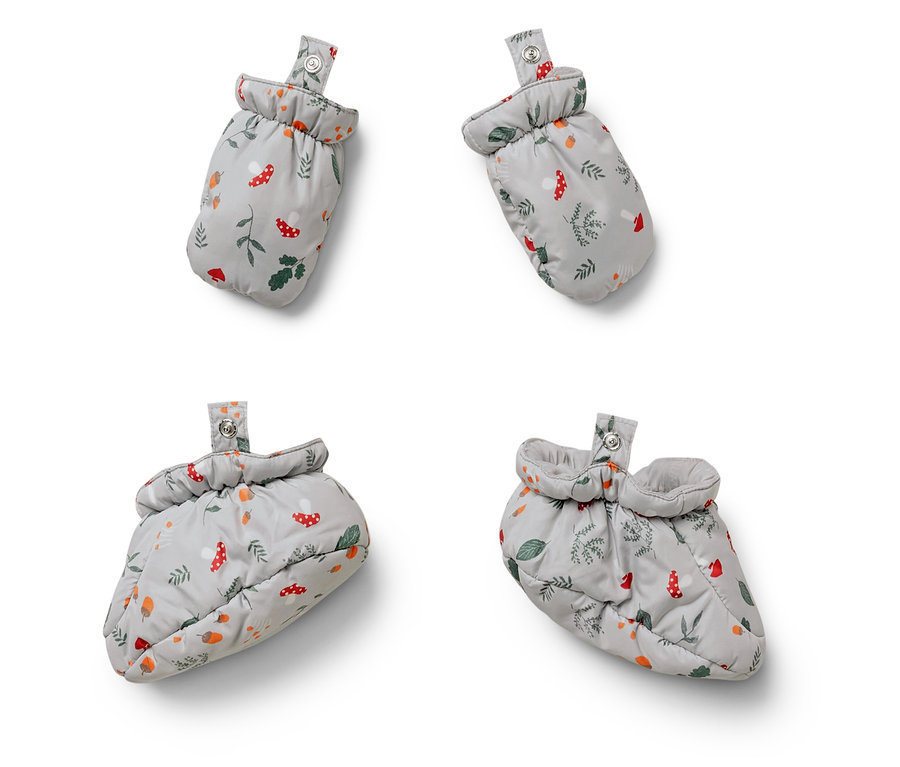 Vier Babyschuhe mit Pilz-, Blatt- und Eichelmuster auf weißem Hintergrund.