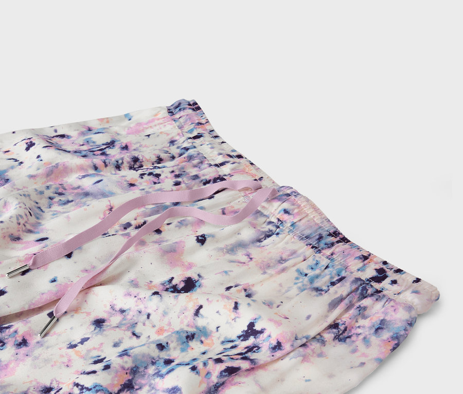 Nahaufnahme der Taille von Shorts mit abstraktem Muster und lila Kordelzug.