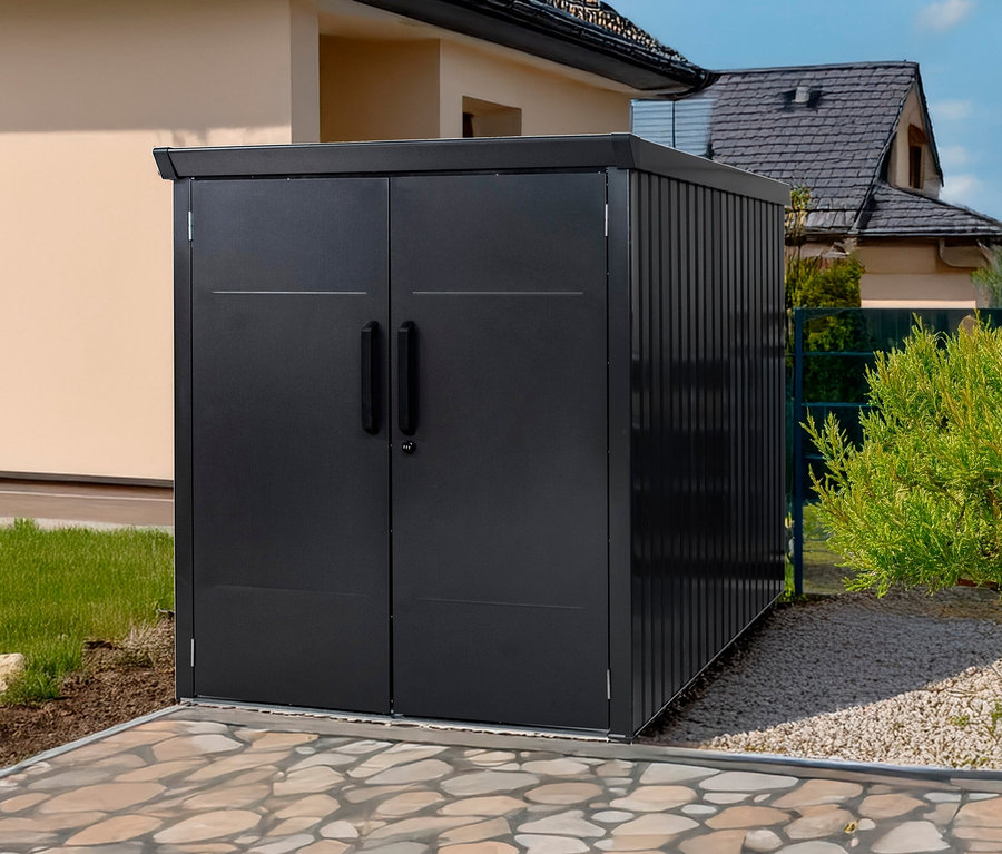 Eine schwarze Fahrradbox steht draußen auf einem gepflasterten Weg.